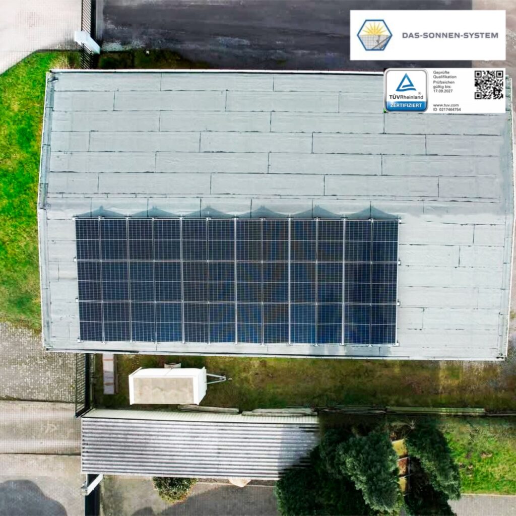 Dach mit Solarpanels und Schornstein, TÜV Zertifikat, sonniger Tag.